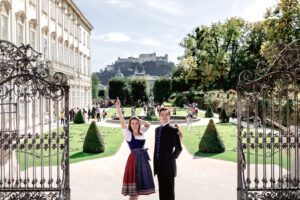 Two entertainers smiling in Mirabell Gardens, Salzburg, marking the final stop of the tour.