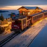 Twilight view of the Singing Xmas Tour Advent Train on Schafberg, with Salzburg’s scenic Christmas lights and mountain views.